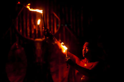 Lit candle in dark room