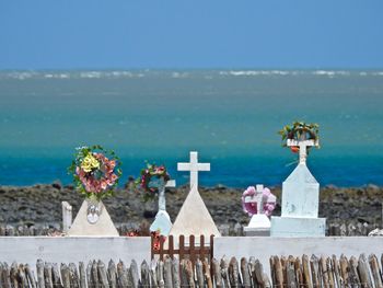 Close-up of cross on beach against clear blue sky