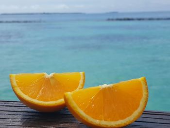 Close-up of orange slices on table against sea