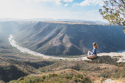 Woman sitting on mountain