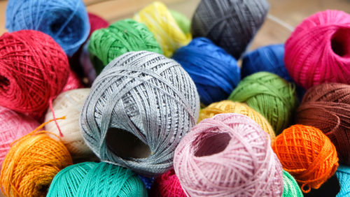 High angle view of colorful thread balls in container on table