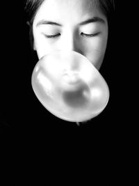 Portrait of woman against black background