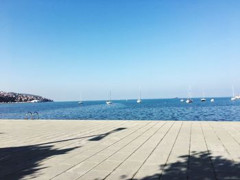 Scenic view of beach against clear blue sky