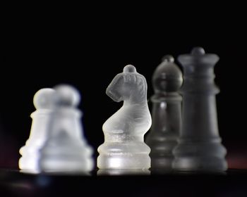 Close-up of chess pieces on table against black background