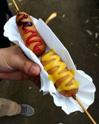 Low section of person holding corn dog