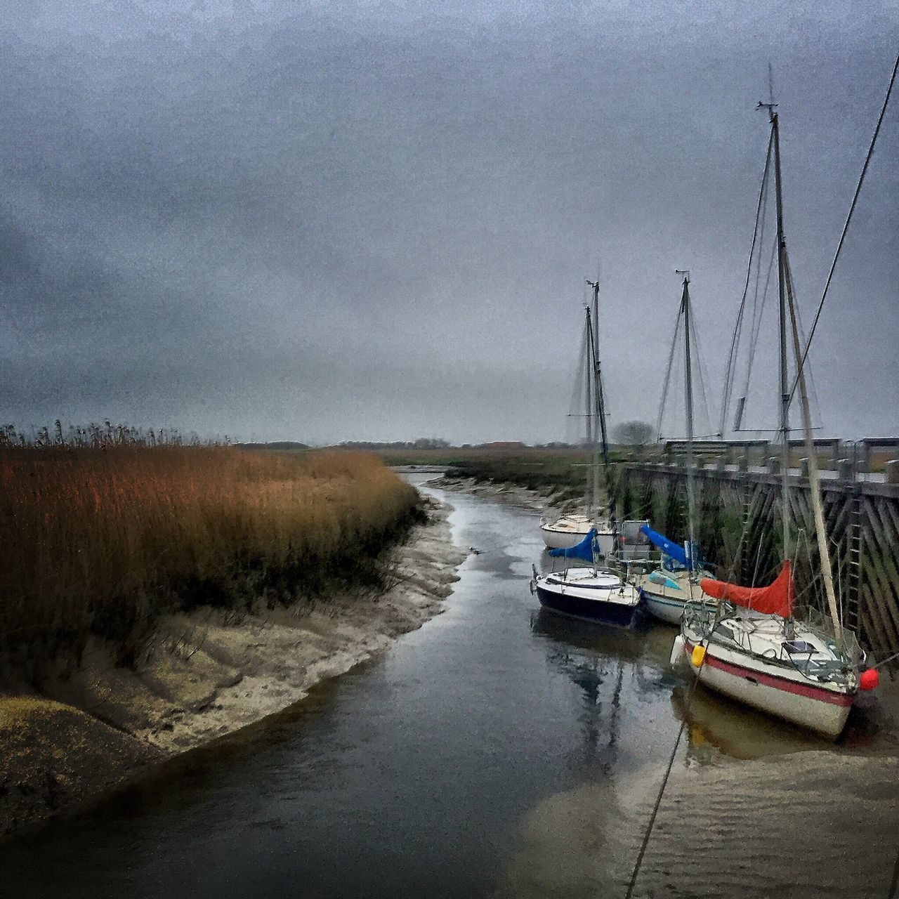 BOATS MOORED AT SEA SHORE AGAINST SKY