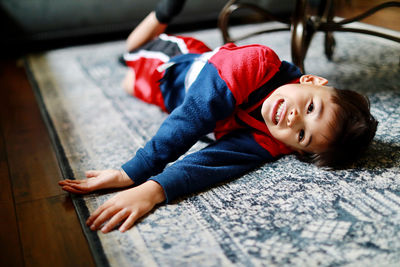 Portrait of boy lying on floor at home