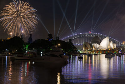 Firework display over river at night