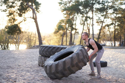 Full length of young man crouching on land
