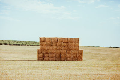 Hay bales on field against sky