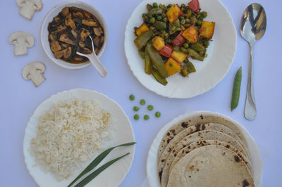 Top view of matar paneer veg, mashroom soup, roti and rice isolated over white background 