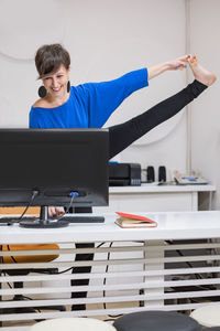 Side view of young woman exercising in gym