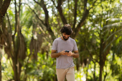 Young man at park on a beautiful sunny day with mobile phone.  working  leisure. green and nature 