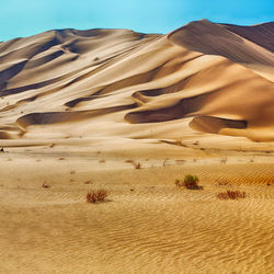 Sand dunes in desert against sky
