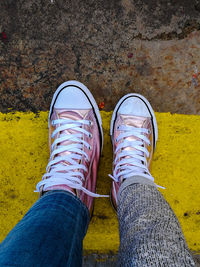 Low section of person standing on yellow shoes