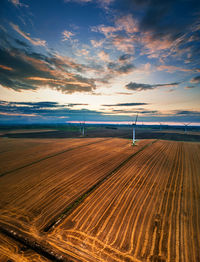 Scenic view of agricultural field against sky during sunset