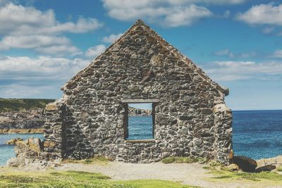 Built structure by sea against sky
