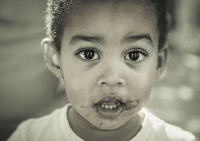 Close-up portrait of cute boy with messy face