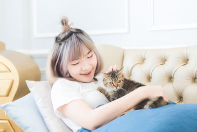 Young woman with kitten at home