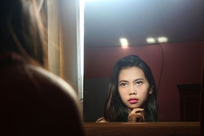 Beautiful woman reflecting in mirror at home