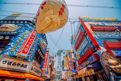 Low angle view of lanterns hanging in city against sky