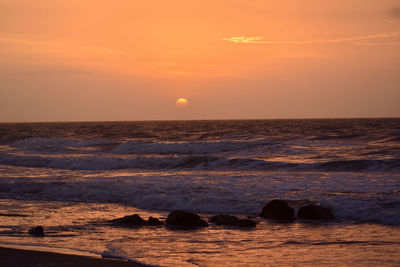 Scenic view of sea against orange sky