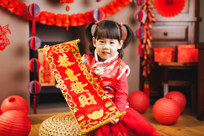 Girl holding lantern sitting at home