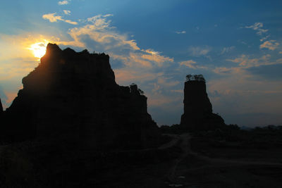 Low angle view of silhouette rock formation against sky during sunset