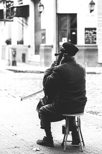 Rear view of woman sitting on floor