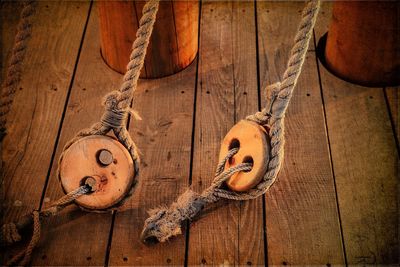 Ropes tied to wooden pulley in boat