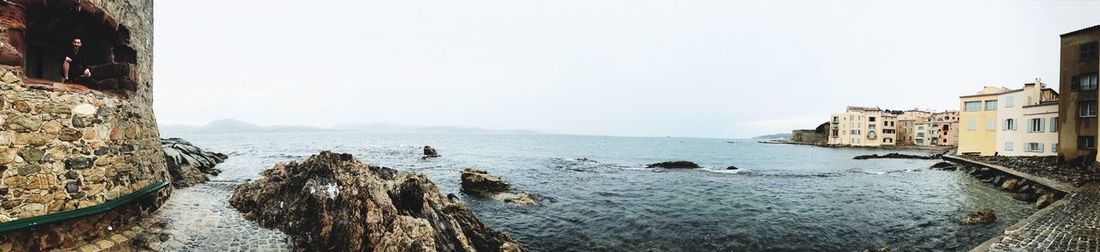 Panoramic view of sea and buildings against clear sky