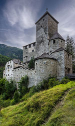 Low angle view of old building against sky and castle