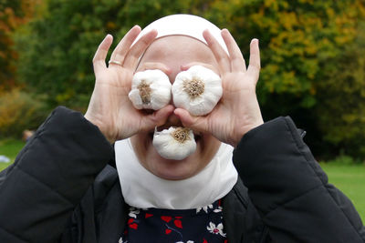 Close-up of woman holding garlic bulbs