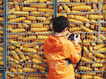 Boy photographing corns at supermarket