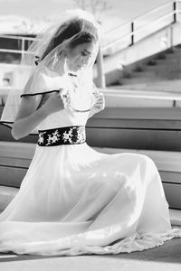 Side view of bride sitting on steps