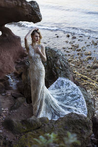 High angle view of young woman wearing gown standing on rock