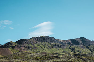 Scenic view of mountains against blue sky