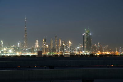 Illuminated city against sky at night