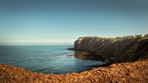 Rock formation on beach against clear sky