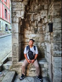 Portrait of young man sitting on steps