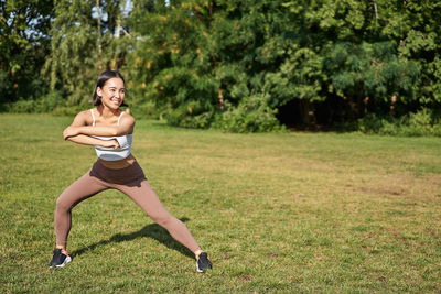 Portrait of young woman exercising in park