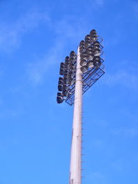 Low angle view of floodlight against blue sky