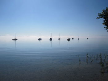 Boats moored on sea against sky