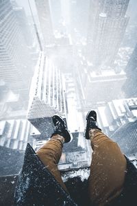 Low section of man against buildings in city during winter