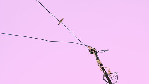 Low angle view of power lines against clear sky