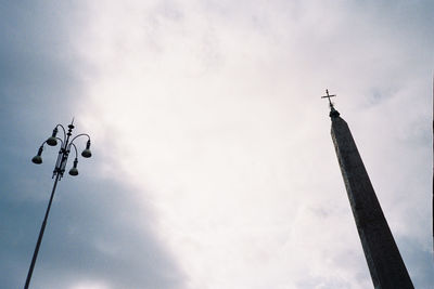 Low angle view of street light by building against sky