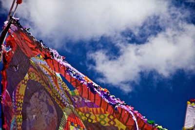 Low angle view of multi colored flags hanging against building