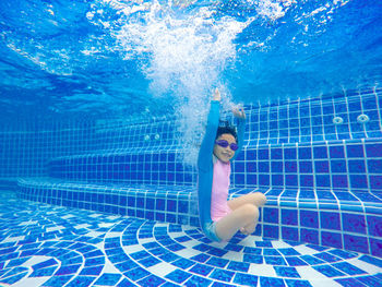 Girl swimming underwater in pool