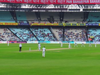 People playing cricket on field