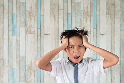 Boy screaming against wall